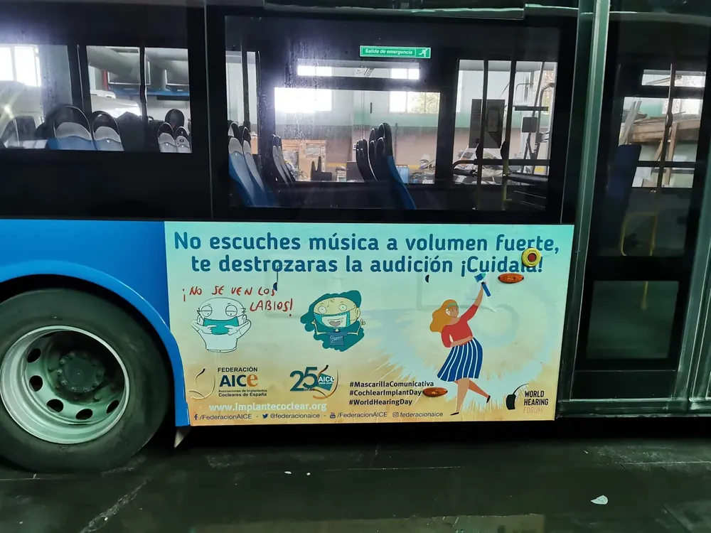 Autobús de campaña de AICE con una viñeta de Pizarrín sobre las dificultades de lectura labial con mascarilla.